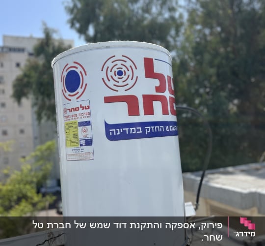 דוד שמש עם מדבקה על גג בניין